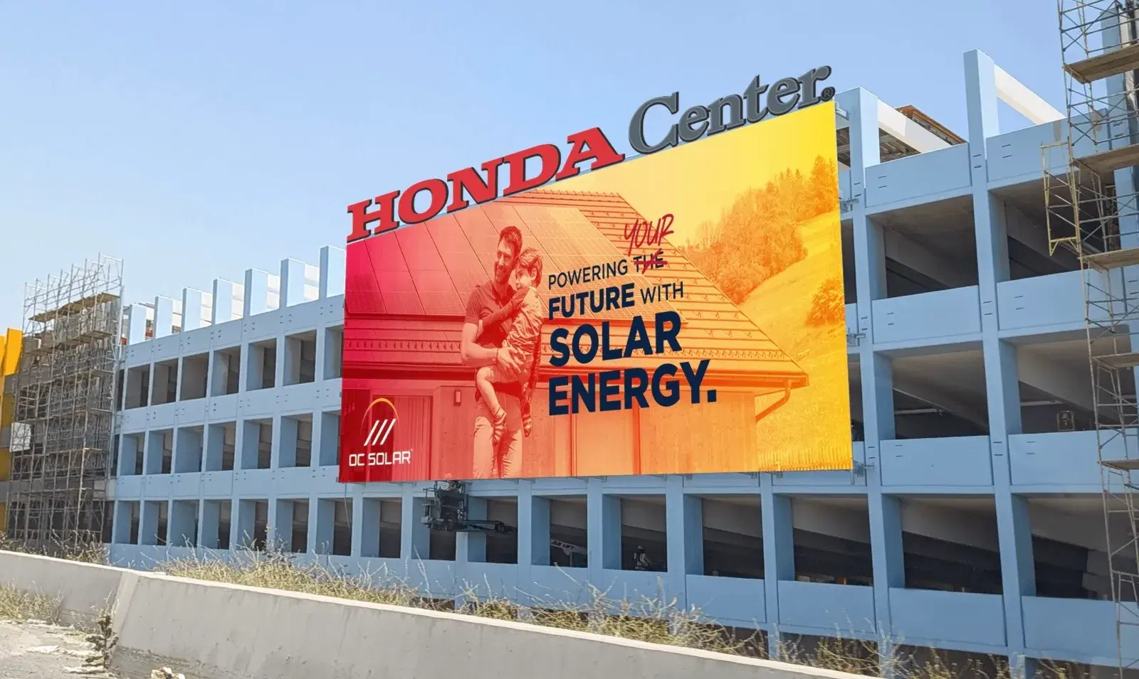 Large orange-and-red OC Solar billboard on the Honda Center parking garage reading Powering Your Future With Solar Energy.