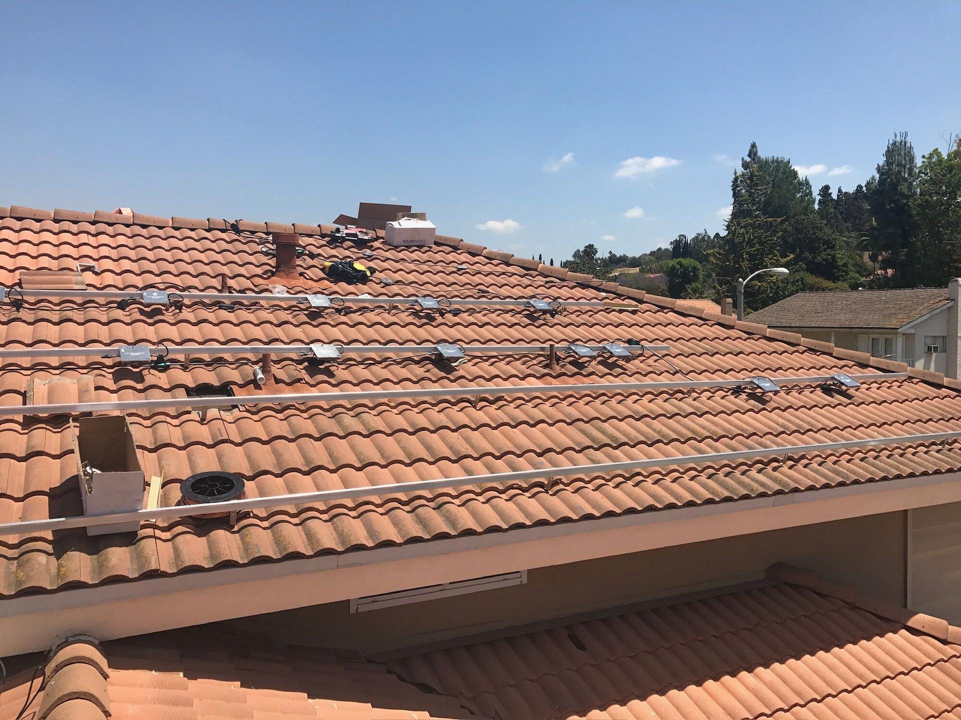 Terracotta tile roof in Southern California with rows of flashed solar standoffs installed, ready for racking
