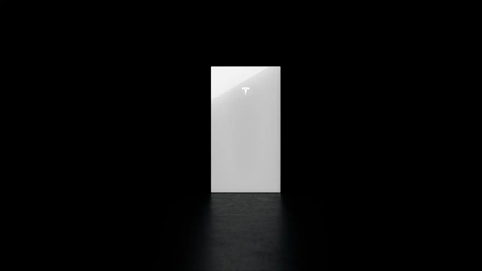 Glossy white Tesla Powerwall battery with a lit Tesla T logo standing alone in a dark studio.