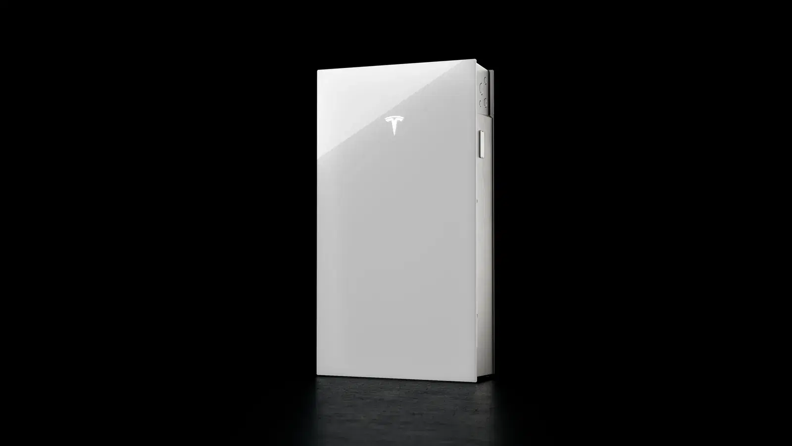 A white Tesla Powerwall home battery photographed on a dark background with the Tesla logo visible.