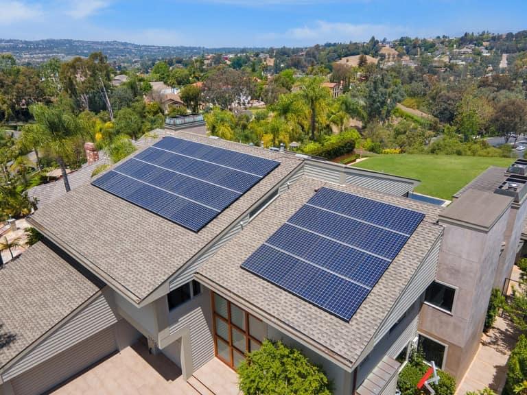 Aerial view of a hillside Southern California home with two OC Solar rooftop panel arrays