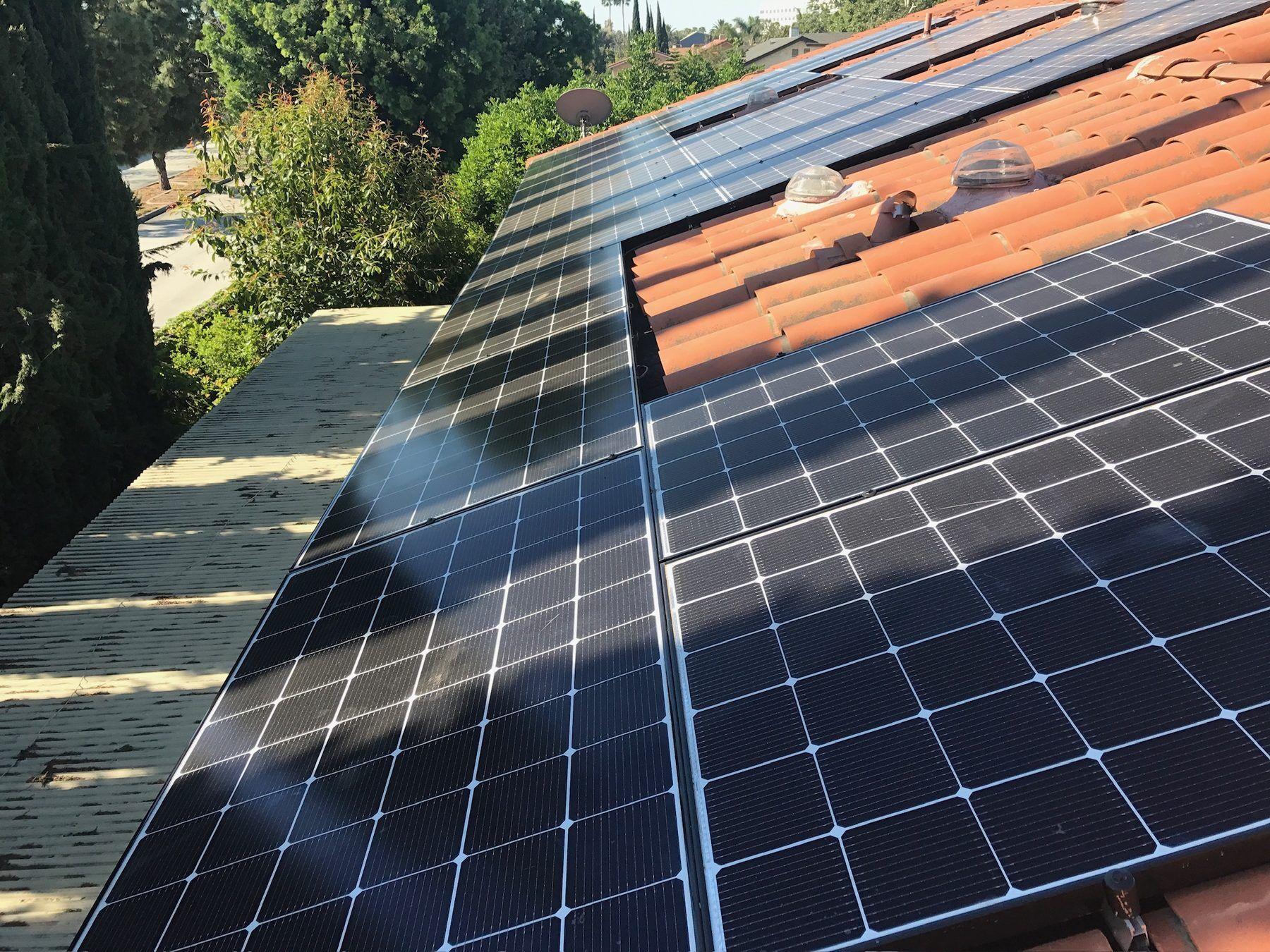 A close-up of solar panels installed on a tile roof