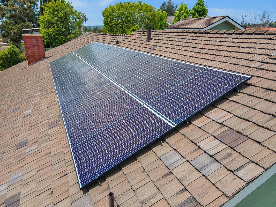 A rooftop solar array spanning the textured shake-style roof of a Southern California home