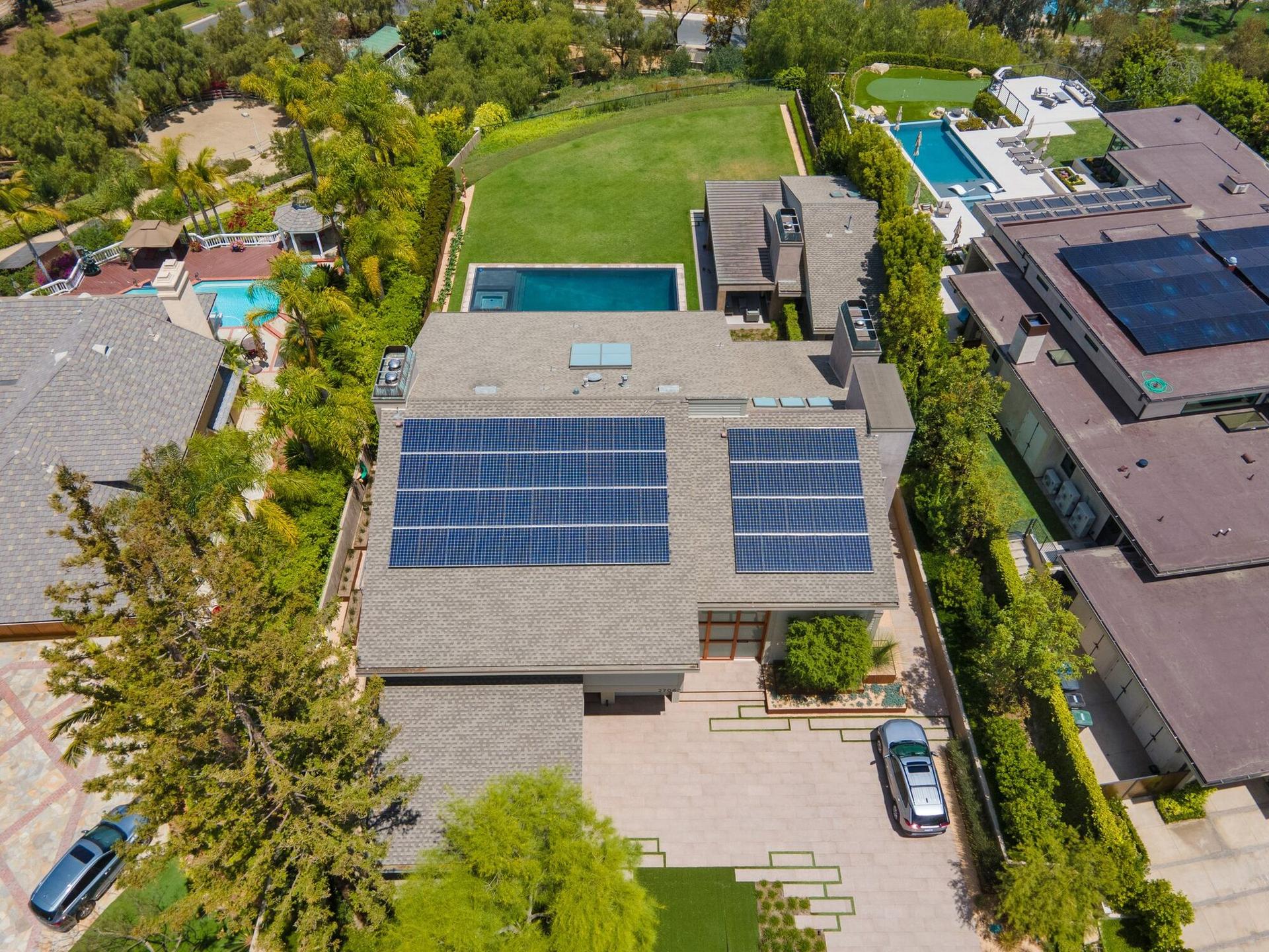 Aerial view of a Southern California estate with two rooftop solar arrays and a backyard pool
