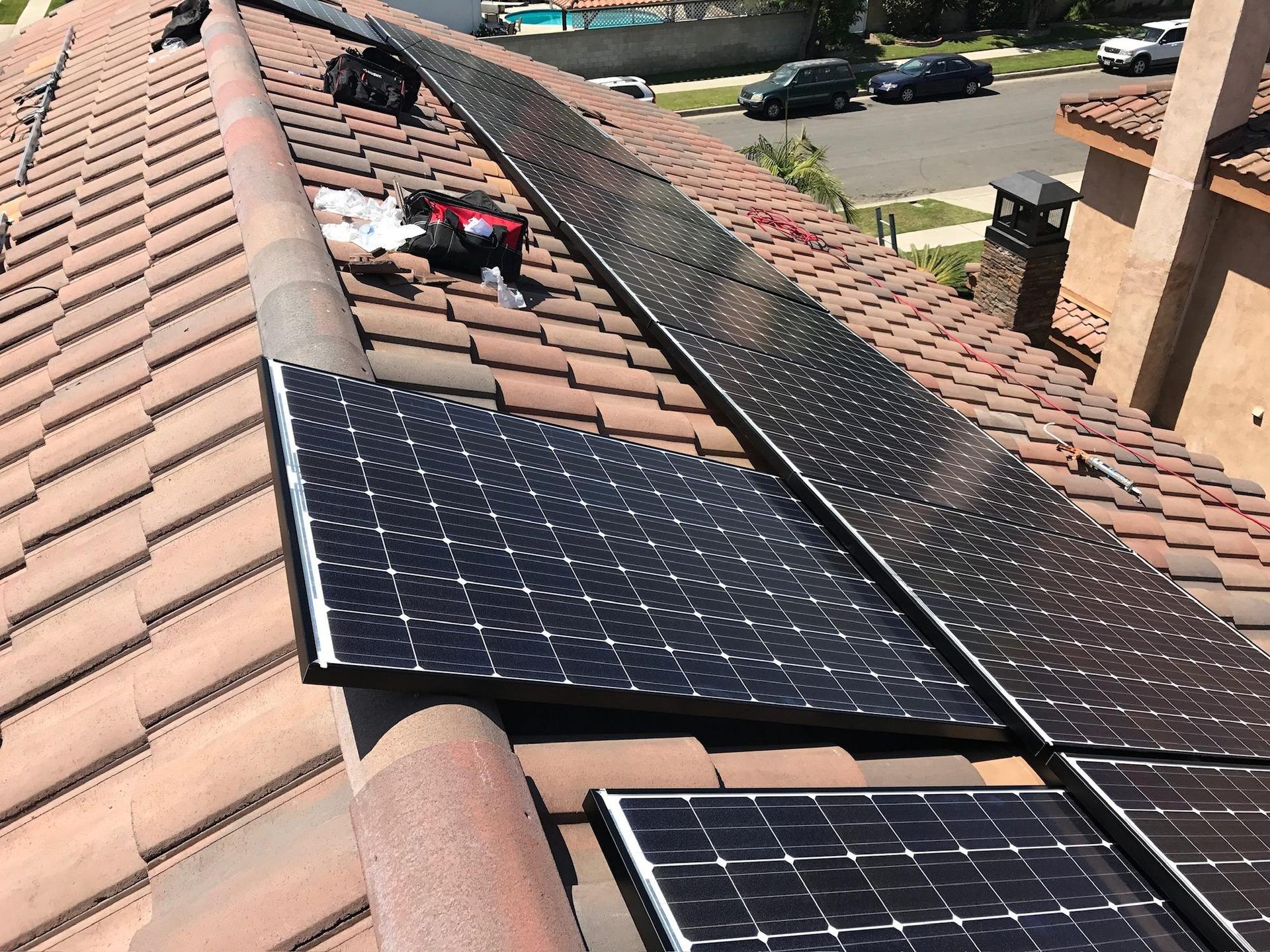 Solar panels staged on a tile roof mid-install at an OC Solar job site