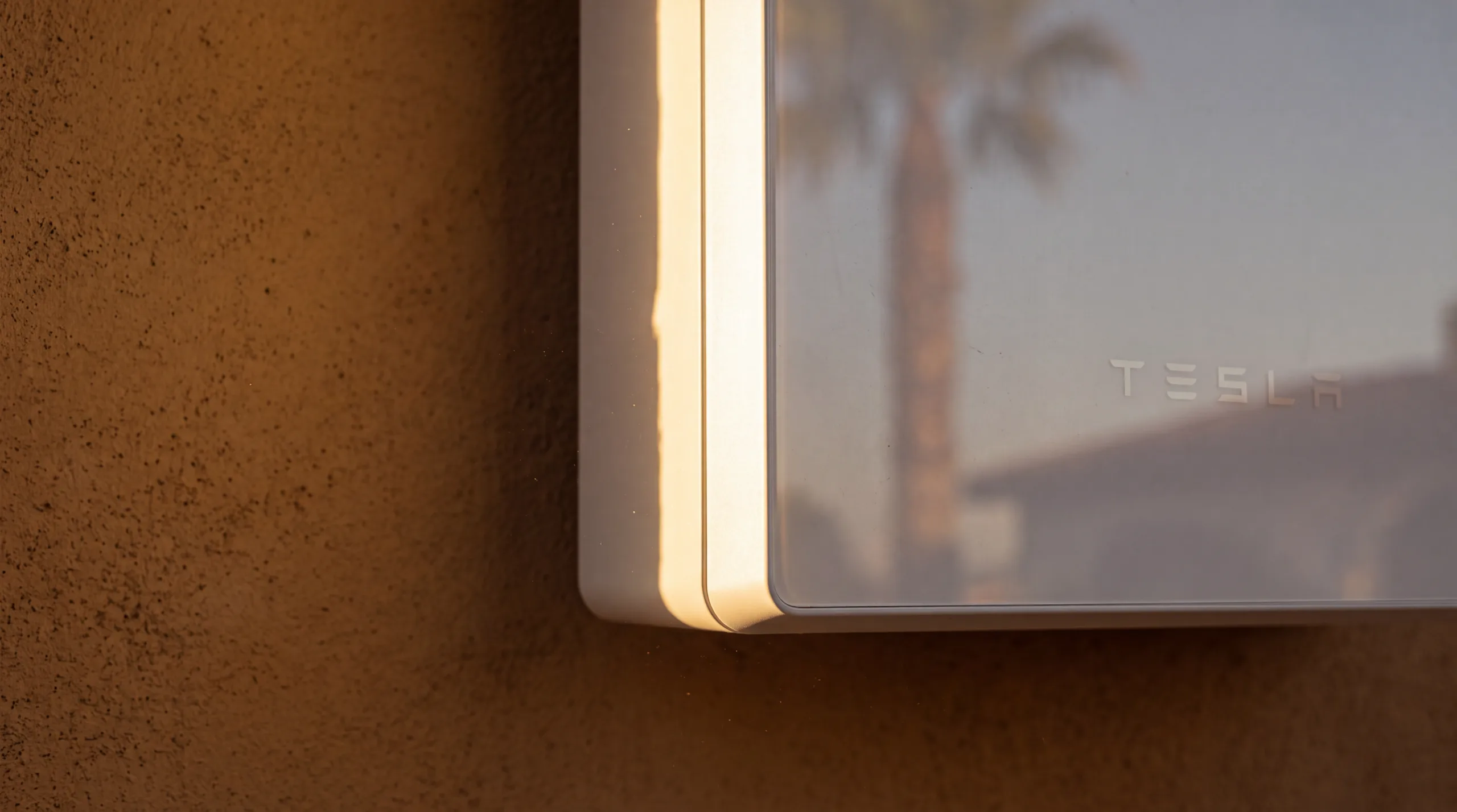 Macro detail of a Tesla Powerwall 3 edge seam in raking golden sidelight
