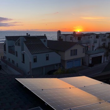 Homes on a beach with solar panels in the foreground